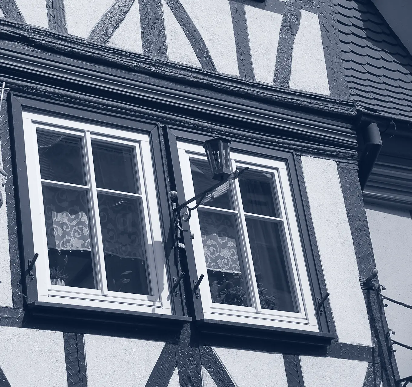 Zwei Sprossenfenster in einer Fachwerkfassade in Miltenberg, einfarbig in Blautönen
